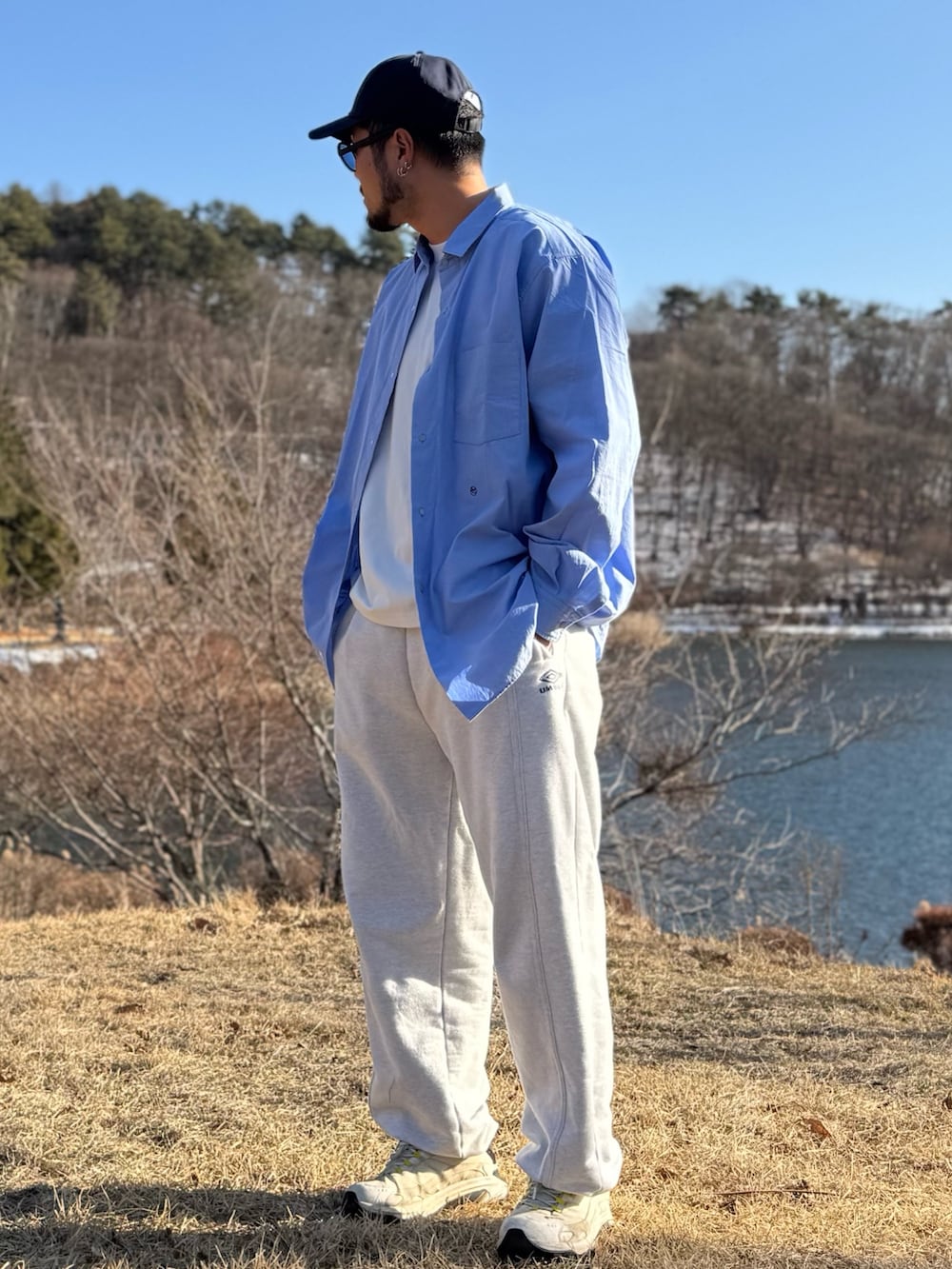 ブルー系のシャツ/ブラウス、ブルー系のキャップ、ブラック系のメガネを着用したメンズの冬コーディネートの2枚目の写真