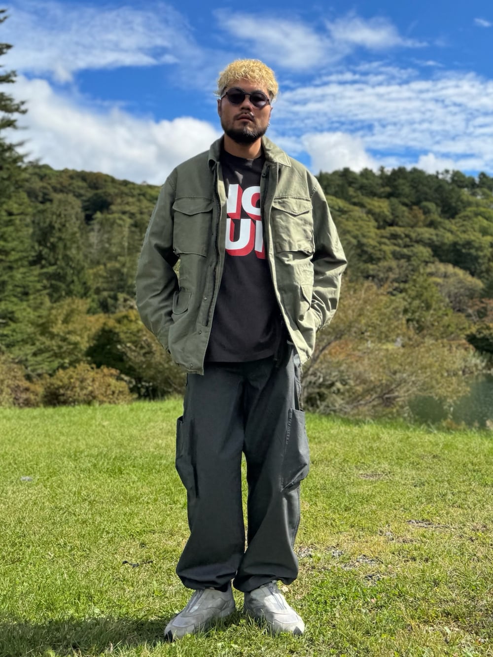 グリーン系のブルゾン、グレー系のその他パンツ、グレー系のTシャツ/カットソーを着用したメンズの秋コーディネートの5枚目の写真