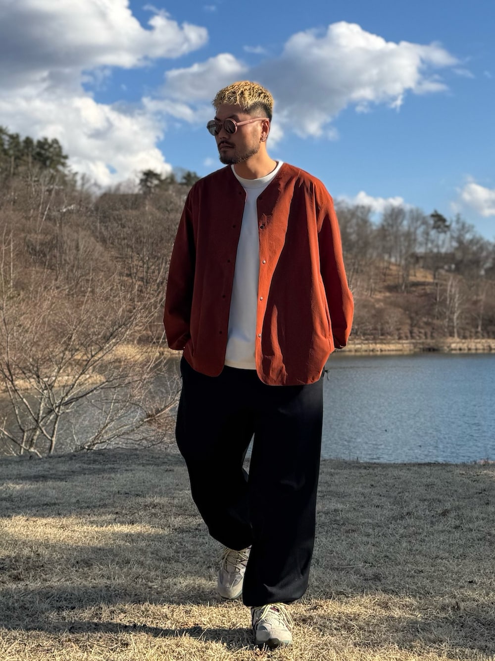 オレンジ系のカーディガン/ボレロ、ブラウン系のメガネを着用したメンズの春コーディネートの2枚目の写真