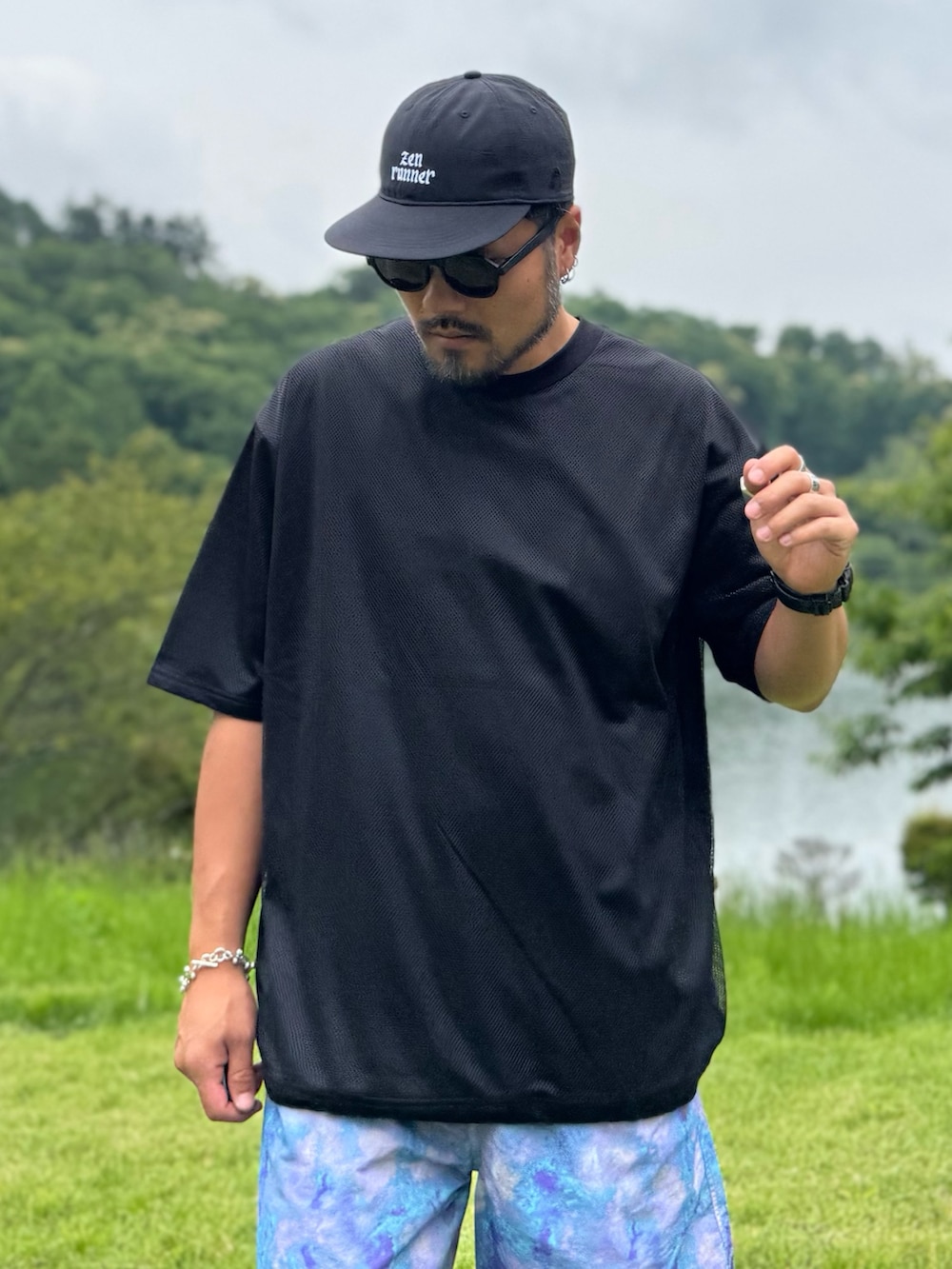 ブラック系のTシャツ/カットソー、パープル系のその他パンツ、ブラック系のキャップを着用したメンズの夏コーディネートの2枚目の写真