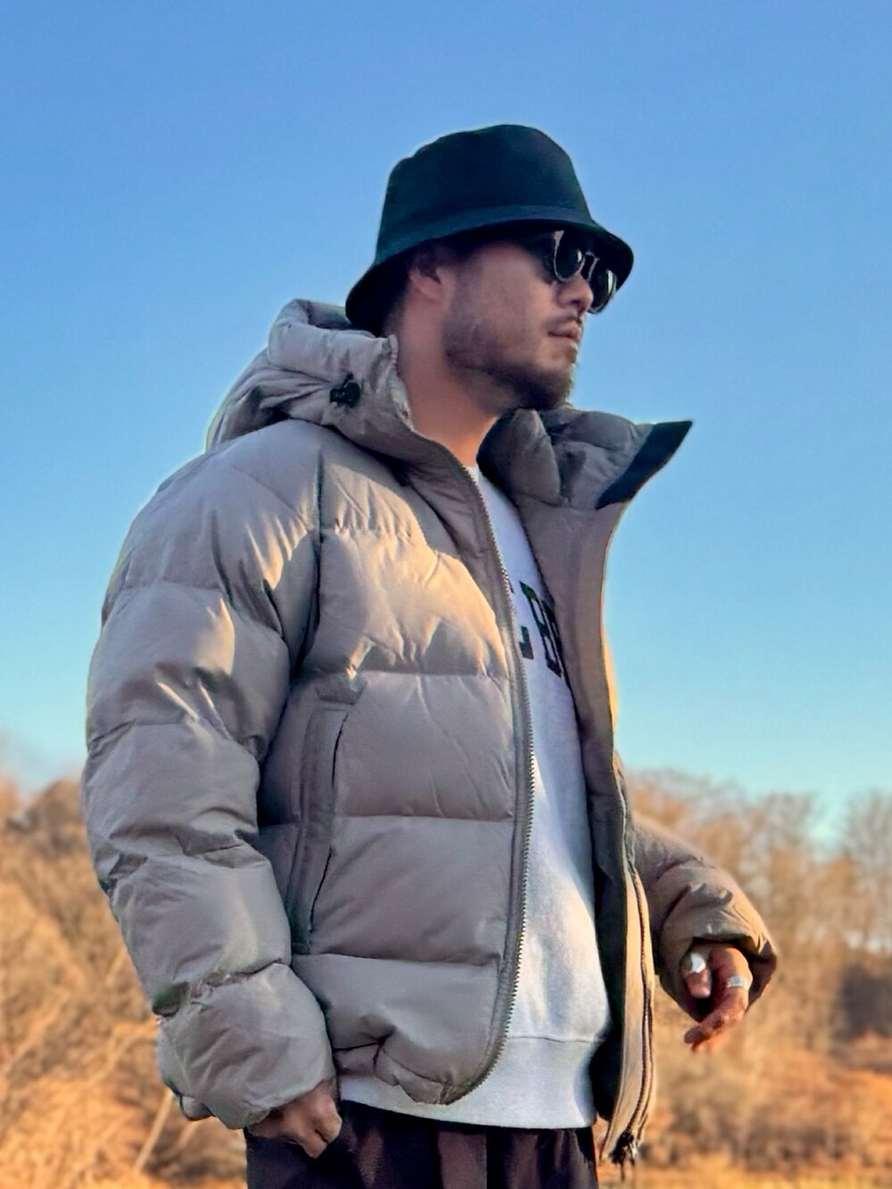 ベージュ系のその他アウター、ブラウン系のその他パンツ、ブラウン系のメガネを着用したメンズの秋コーディネートの4枚目の写真