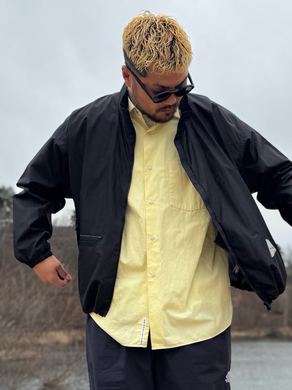 ブラック系のテーラードジャケット、ブラック系のメガネを着用したメンズの春コーディネートの2枚目の写真