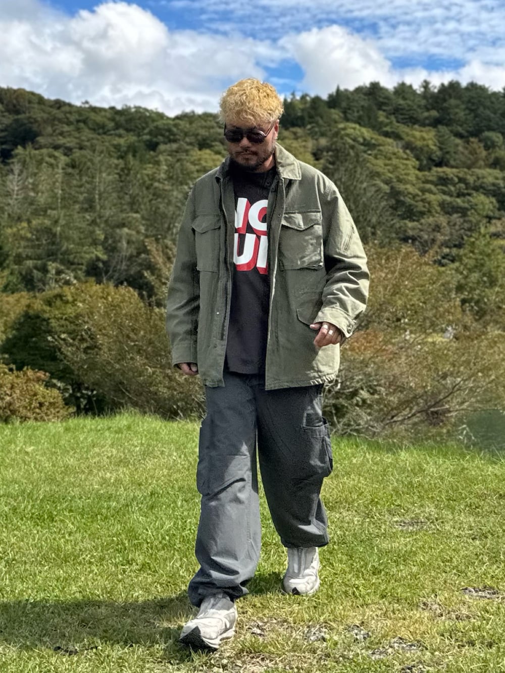 グリーン系のブルゾン、グレー系のその他パンツ、グレー系のTシャツ/カットソーを着用したメンズの秋コーディネートの3枚目の写真