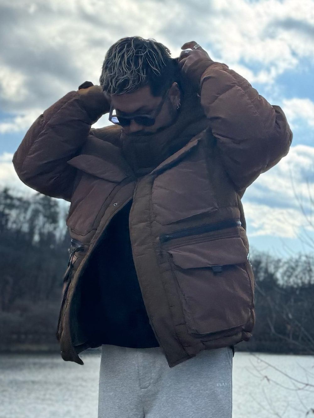 ブラウン系のその他アウター、グレー系のその他パンツ、ブラック系のメガネを着用したメンズの冬コーディネートの5枚目の写真