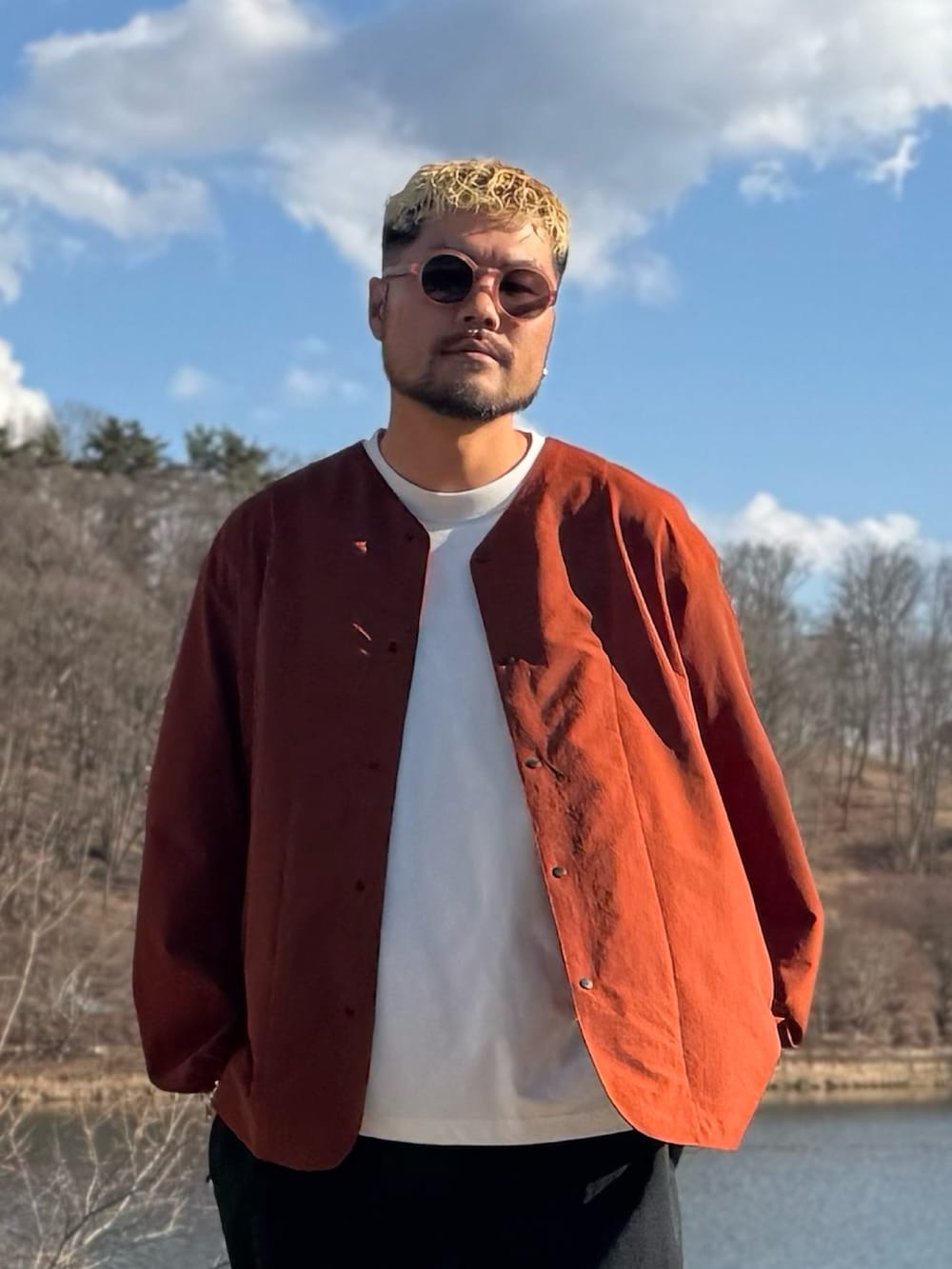 オレンジ系のカーディガン/ボレロ、ブラウン系のメガネを着用したメンズの春コーディネートの4枚目の写真