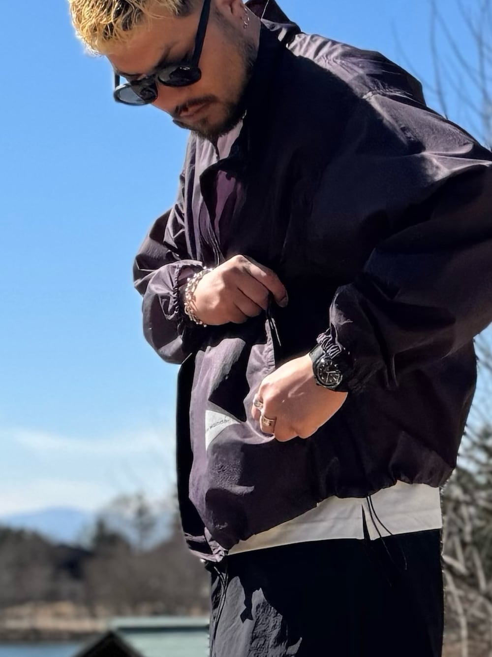 パープル系のテーラードジャケット、ブラック系のメガネを着用したメンズの春コーディネートの4枚目の写真