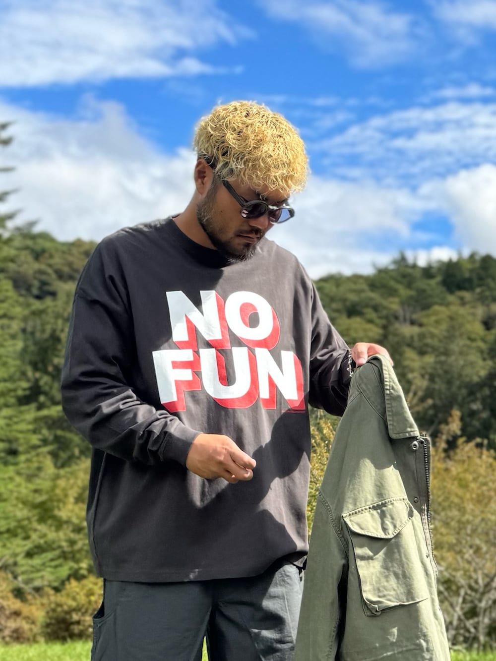 グリーン系のブルゾン、グレー系のその他パンツ、グレー系のTシャツ/カットソーを着用したメンズの秋コーディネートの6枚目の写真