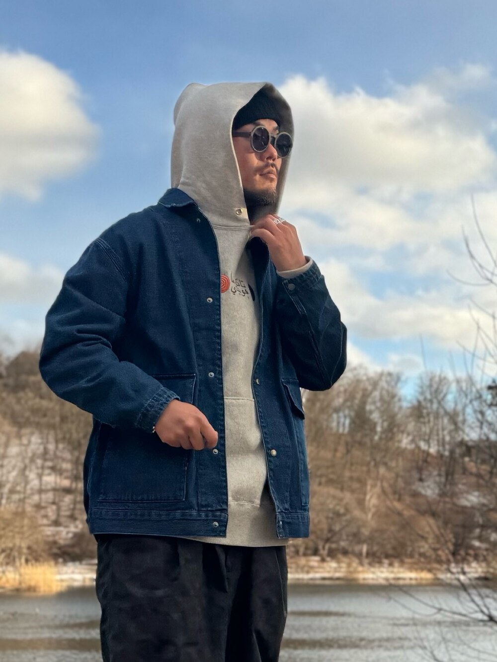 ベージュ系のパーカー、ブルー系のカバーオール、ブラック系のその他パンツを着用したメンズの冬コーディネートの4枚目の写真