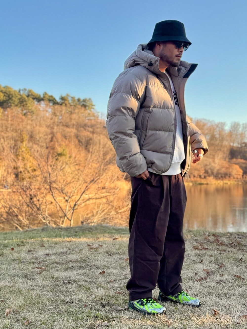 ベージュ系のその他アウター、ブラウン系のその他パンツ、ブラウン系のメガネを着用したメンズの秋コーディネートの2枚目の写真