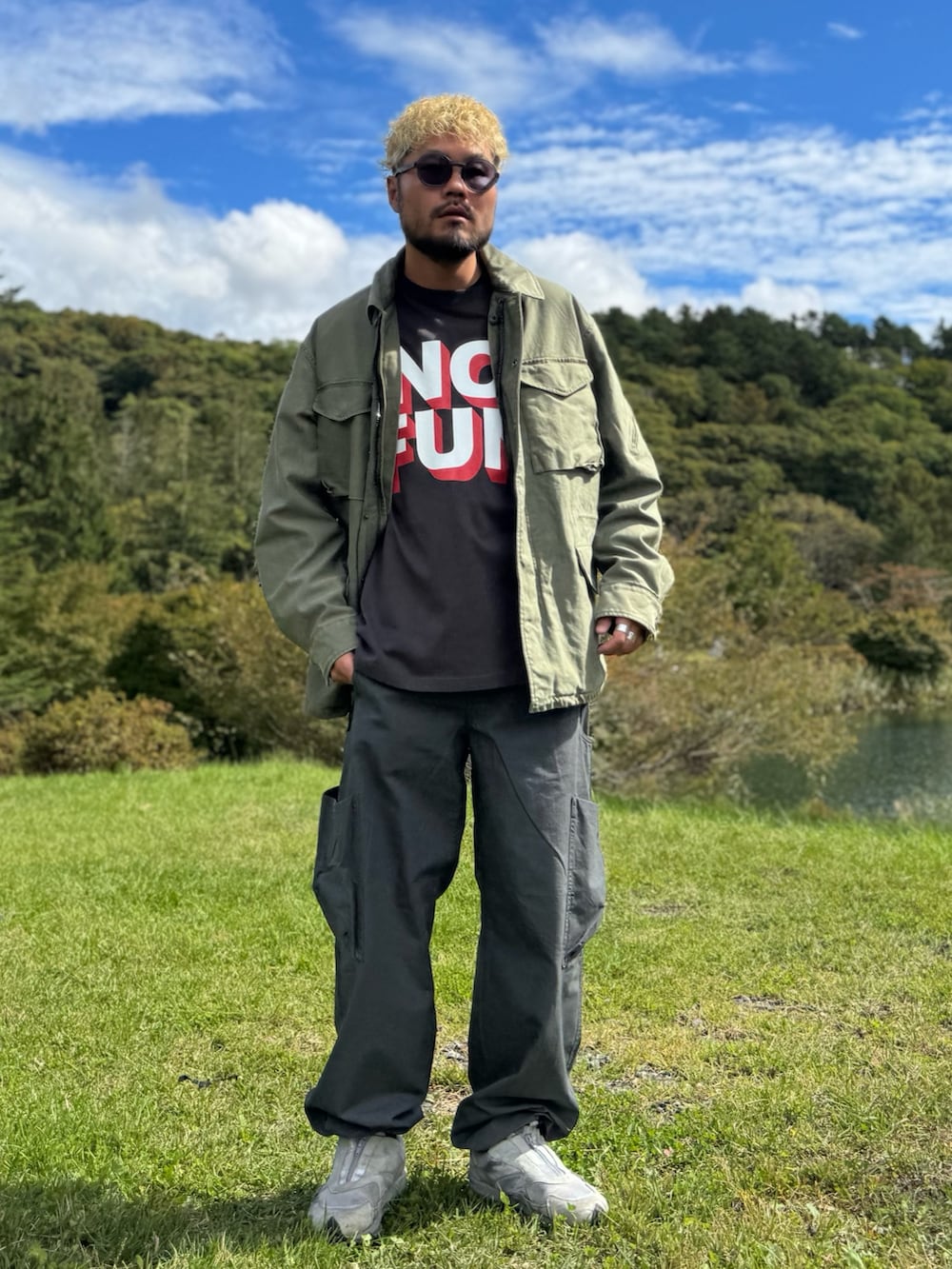 グリーン系のブルゾン、グレー系のその他パンツ、グレー系のTシャツ/カットソーを着用したメンズの秋コーディネートの2枚目の写真