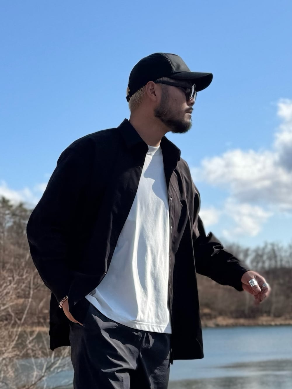 ブラック系のシャツ/ブラウス、ブラック系のキャップ、ブラック系のメガネを着用したメンズの春コーディネートの2枚目の写真