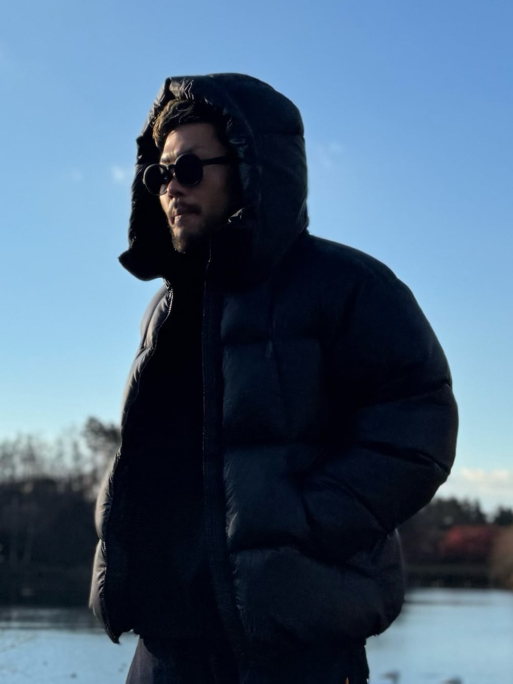 ブラック系のダウンジャケット/コート、ブラック系のメガネを着用したメンズの冬コーディネートの4枚目の写真