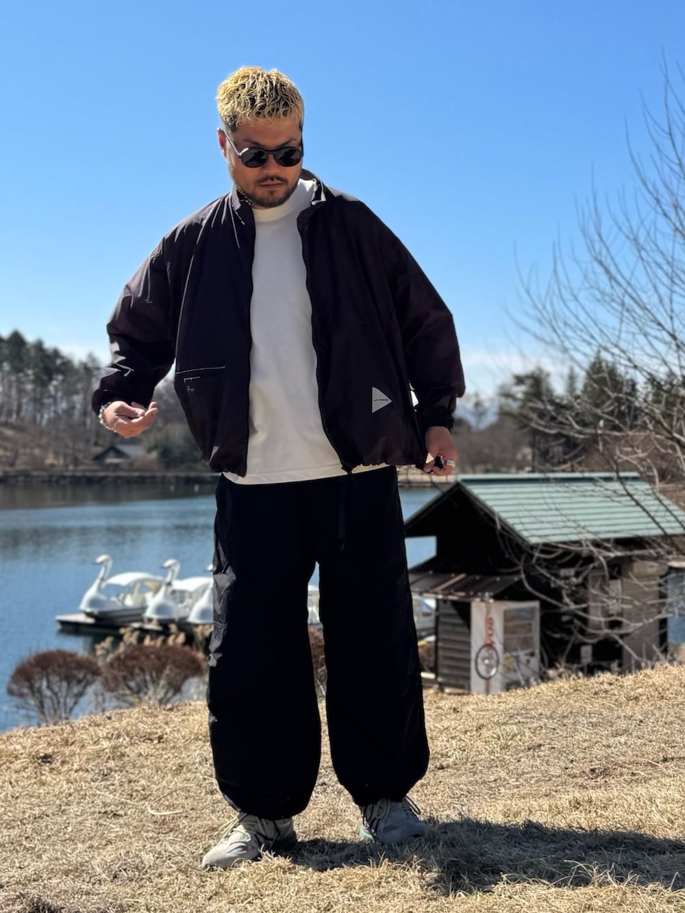 パープル系のテーラードジャケット、ブラック系のメガネを着用したメンズの春コーディネートの2枚目の写真