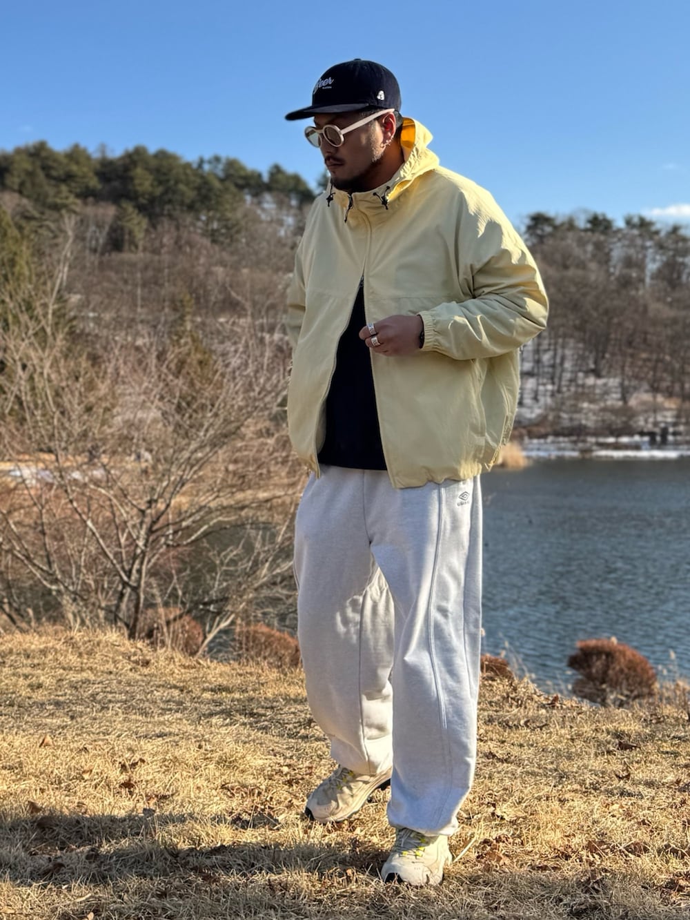 イエロー系のナイロンジャケット、ホワイト系のメガネを着用したメンズの冬コーディネートの2枚目の写真