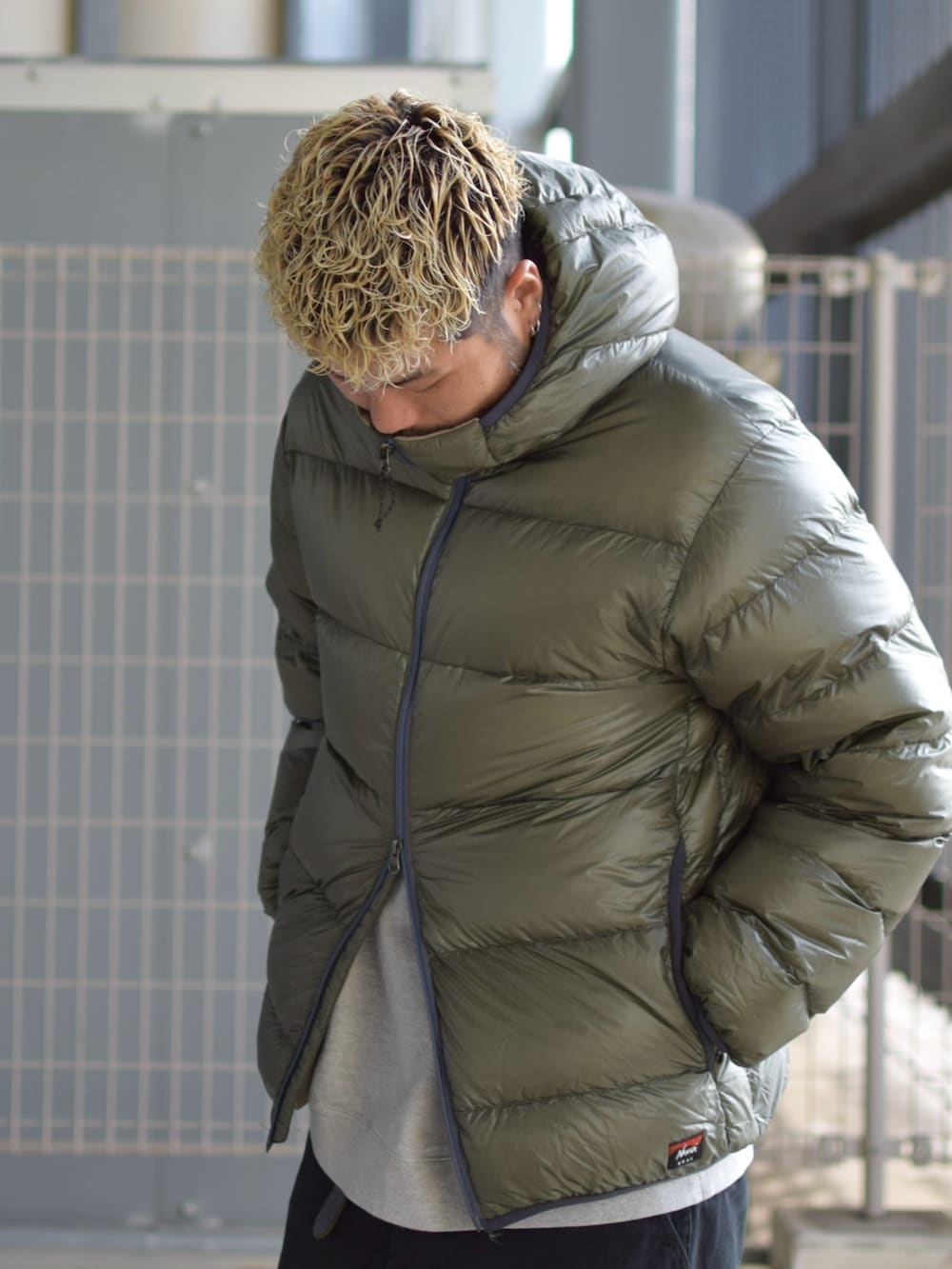 グリーン系のダウンジャケット/コート、グレー系のスウェット、ブラック系のチノパンツを着用したメンズの冬コーディネートの4枚目の写真