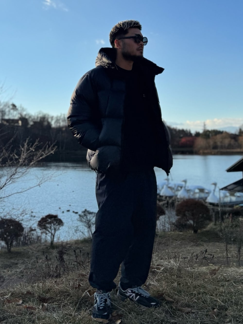 ブラック系のダウンジャケット/コート、ブラック系のメガネを着用したメンズの冬コーディネートの2枚目の写真