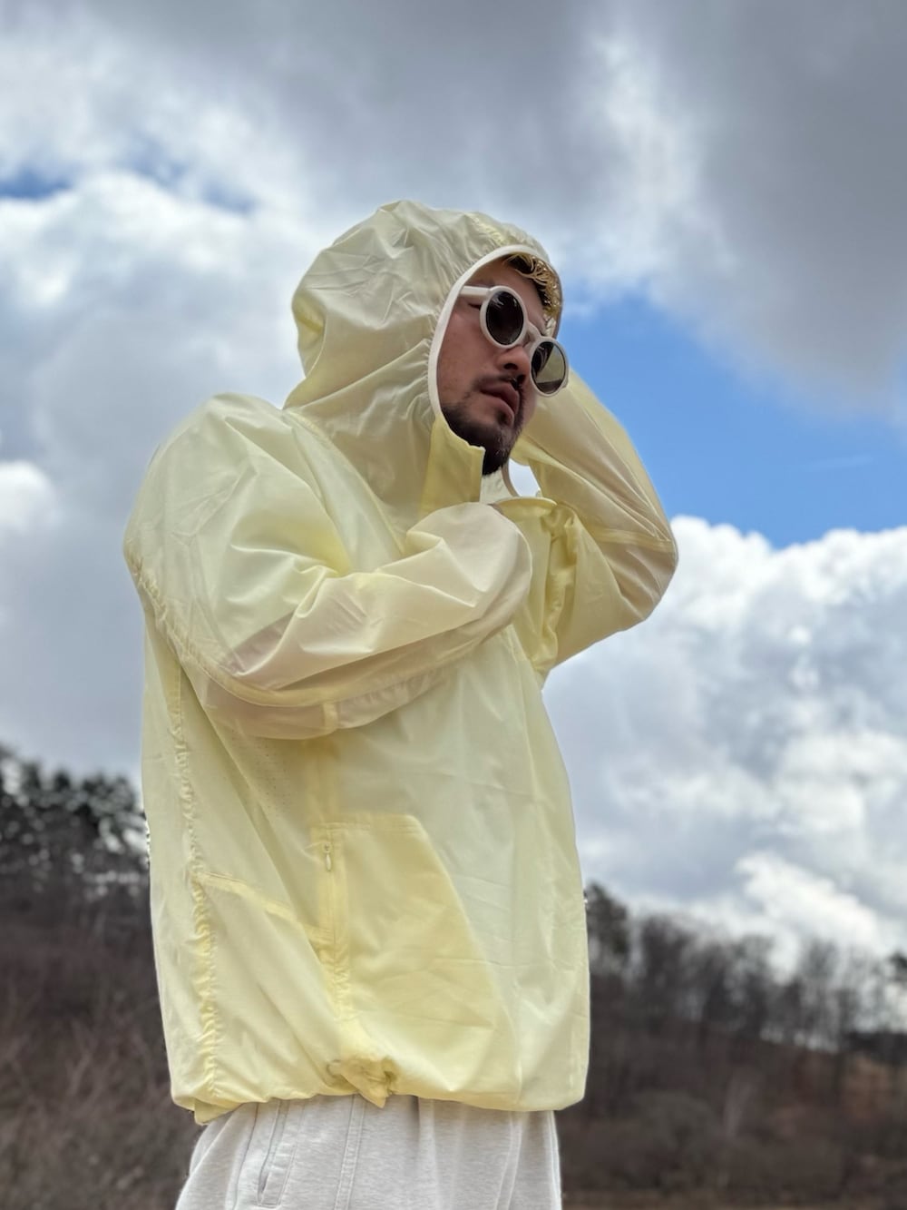 イエロー系のナイロンジャケット、ホワイト系のメガネを着用したメンズの春コーディネートの4枚目の写真