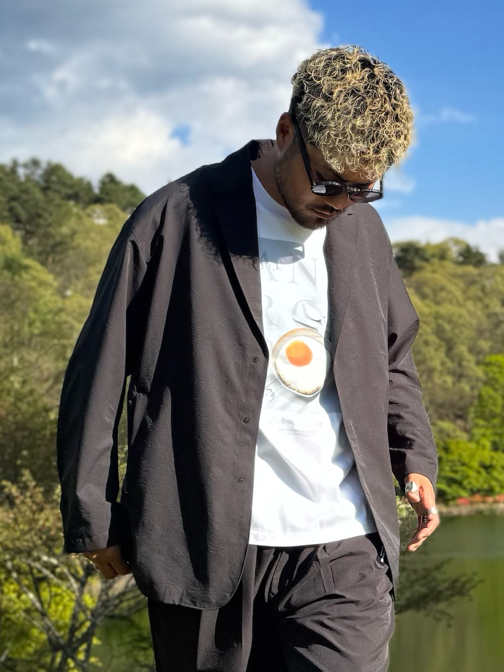 ブラック系のその他アウター、ホワイト系のTシャツ/カットソー、ブラック系のその他パンツを着用したメンズの春コーディネートの2枚目の写真