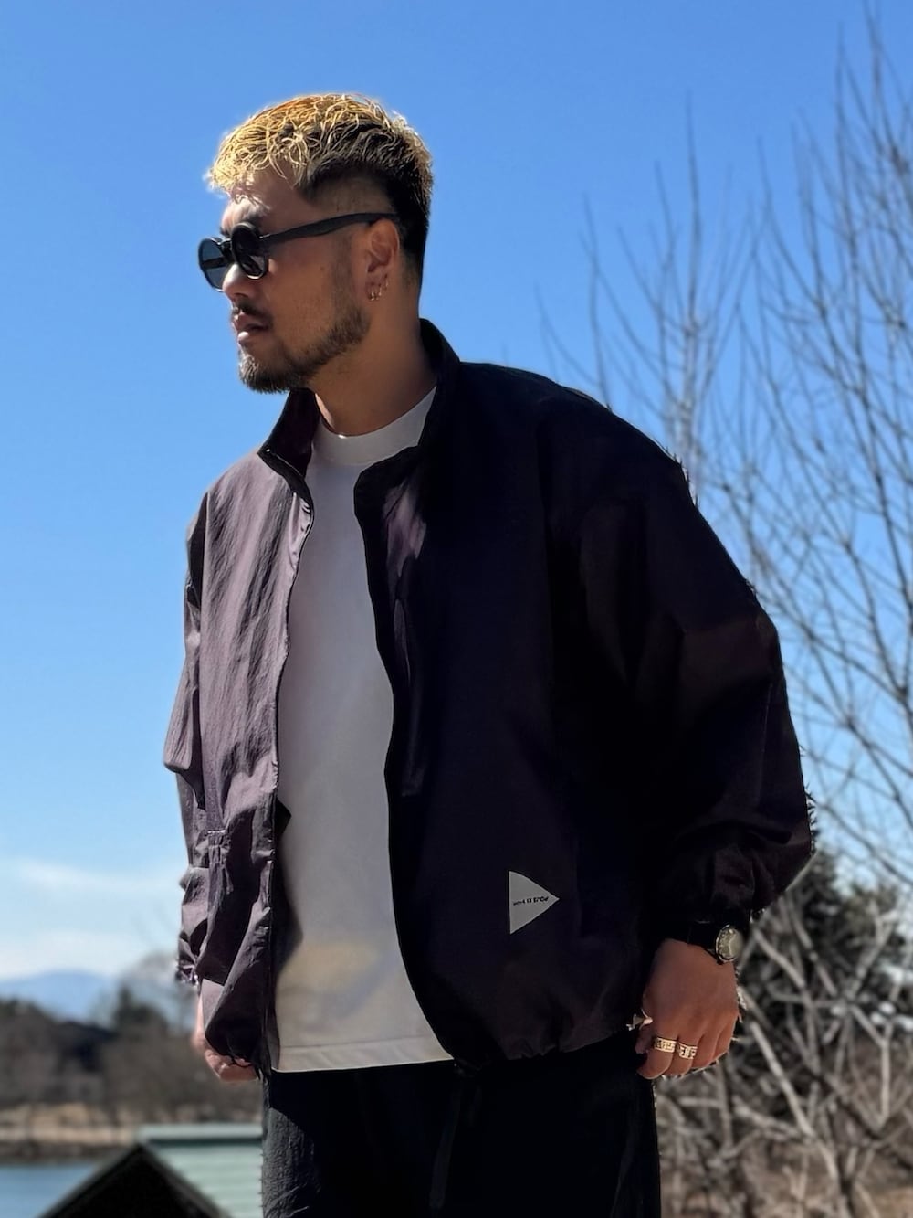 パープル系のテーラードジャケット、ブラック系のメガネを着用したメンズの春コーディネートの5枚目の写真