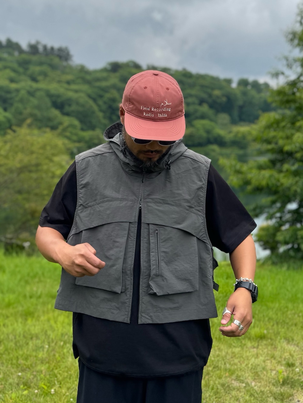 ブラック系のTシャツ/カットソー、グレー系のダウンベスト、ブラック系のメガネを着用したメンズの夏コーディネートの5枚目の写真