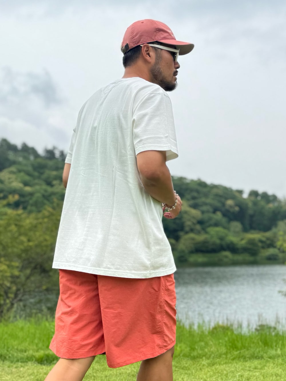 オレンジ系のその他パンツ、ホワイト系のTシャツ/カットソー、オレンジ系のキャップを着用したメンズの夏コーディネートの2枚目の写真