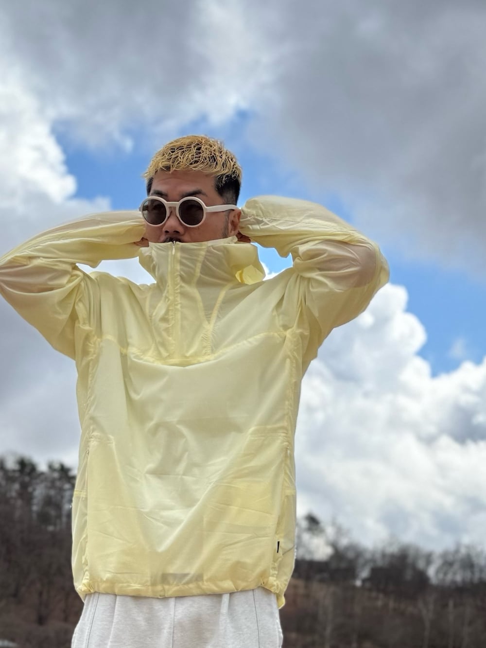 イエロー系のナイロンジャケット、ホワイト系のメガネを着用したメンズの春コーディネートの3枚目の写真