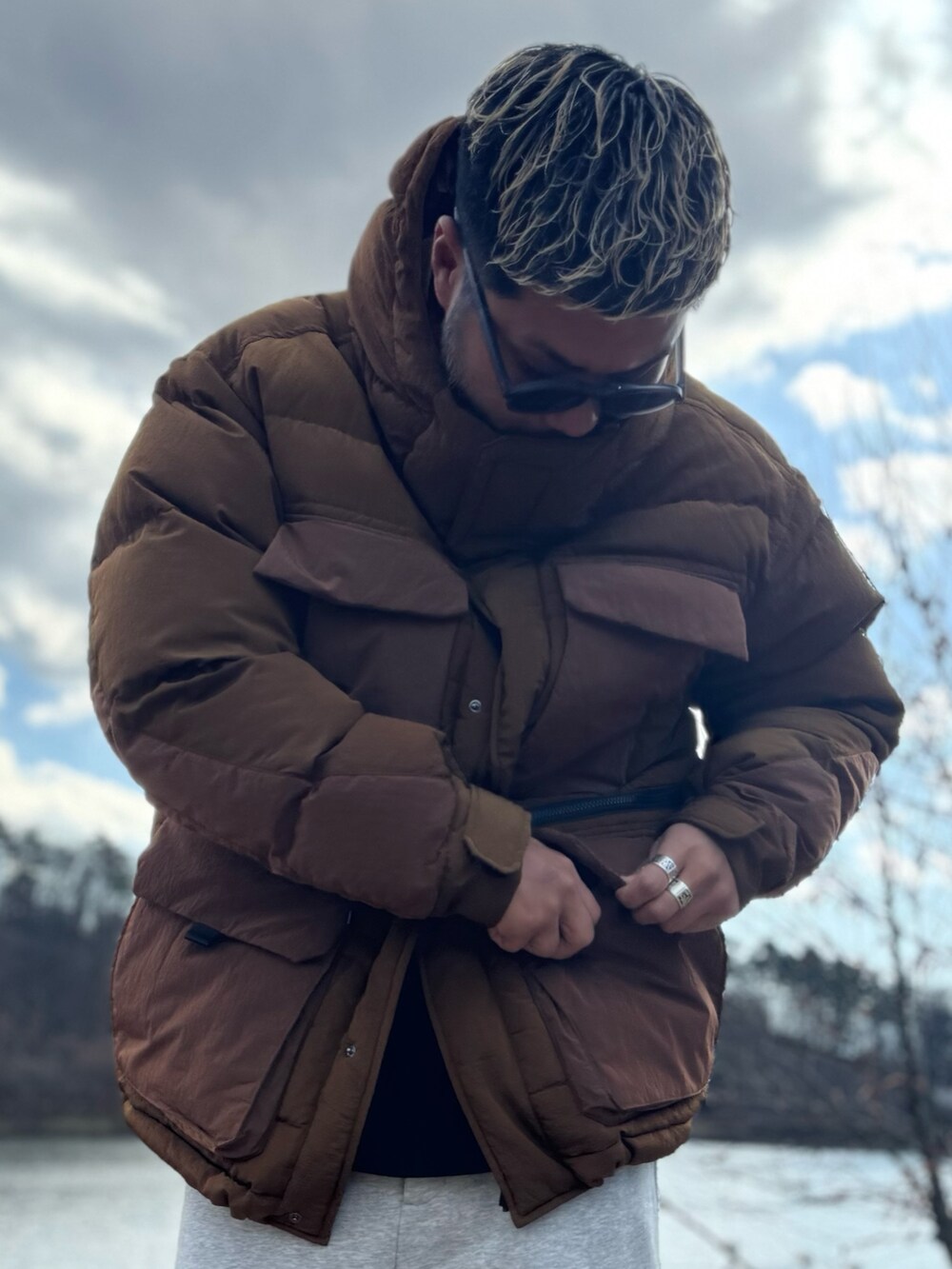 ブラウン系のその他アウター、グレー系のその他パンツ、ブラック系のメガネを着用したメンズの冬コーディネートの3枚目の写真