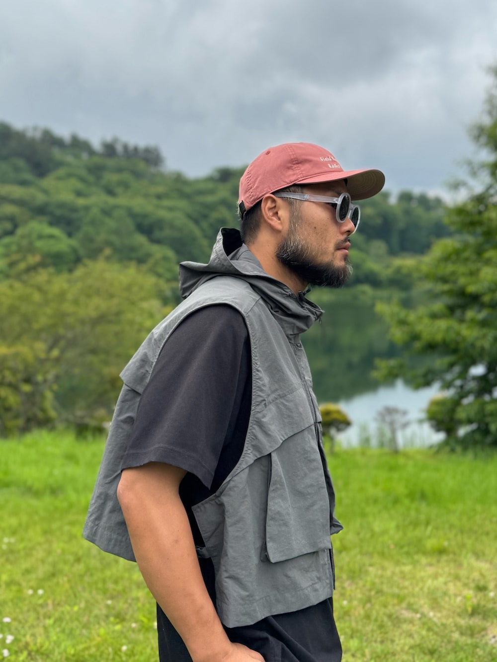 ブラック系のTシャツ/カットソー、グレー系のダウンベスト、ブラック系のメガネを着用したメンズの夏コーディネートの4枚目の写真