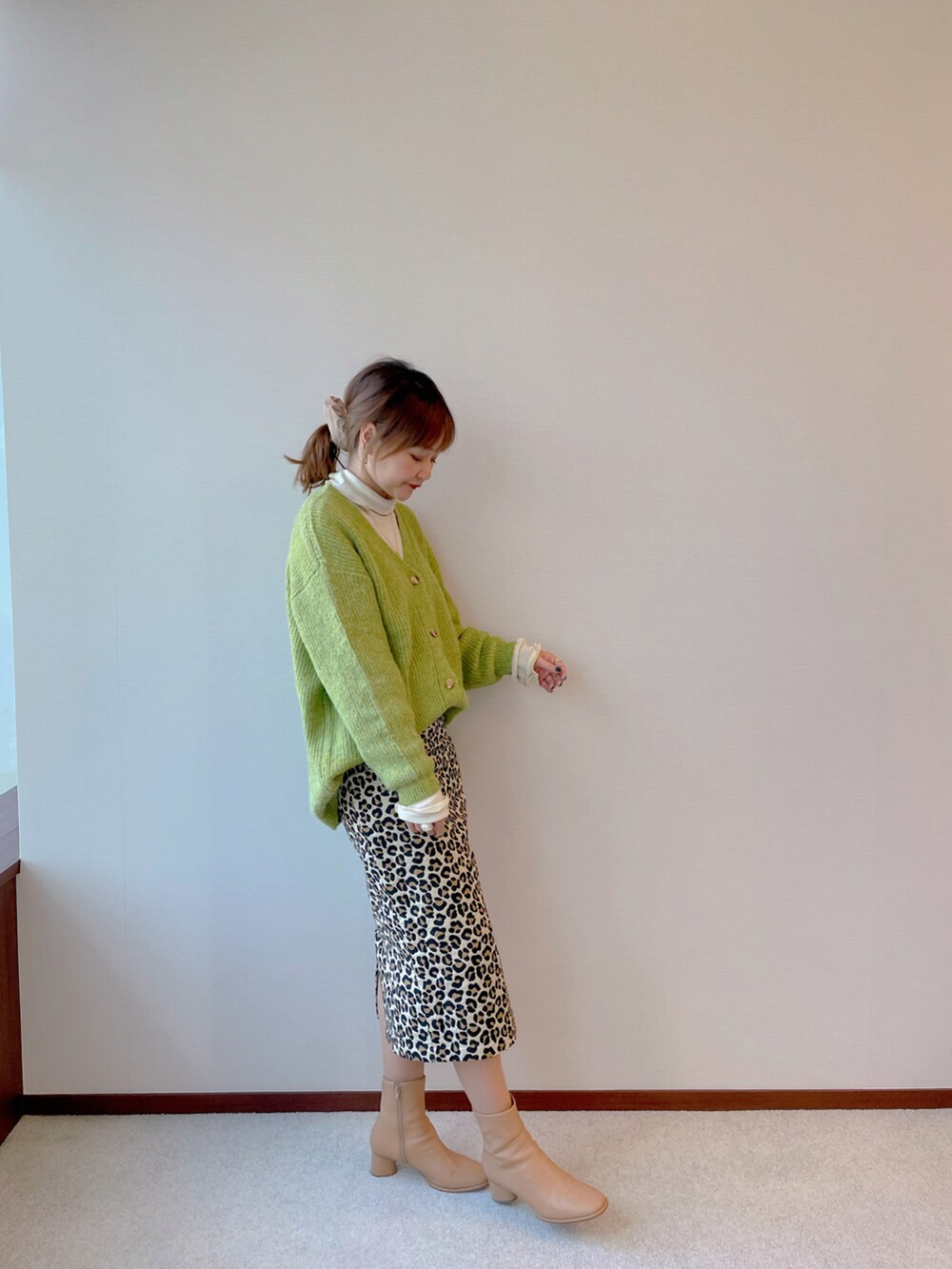 グリーン系のアンサンブル、ベージュ系のスカートを着用したレディースの冬コーディネートの3枚目の写真