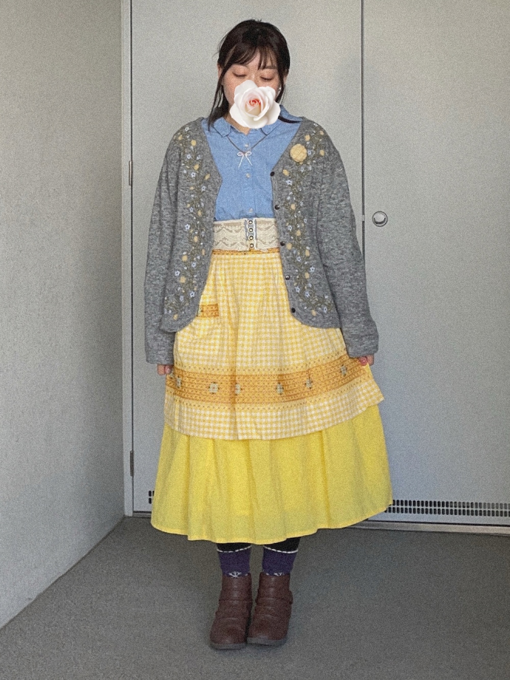 イエロー系のスカート、ブラウン系のブーティ、ブルー系のシャツ/ブラウスを着用したレディースの冬コーディネートの2枚目の写真