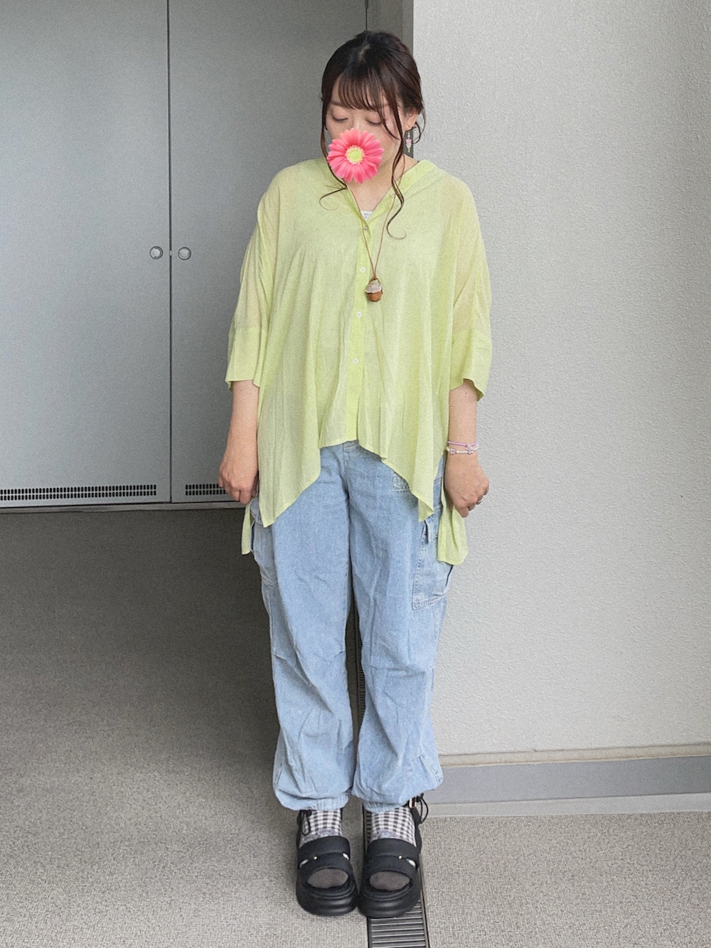 グリーン系のシャツ/ブラウス、ブルー系のデニムパンツ、ブラック系のサンダルを着用したレディースの夏コーディネートの3枚目の写真