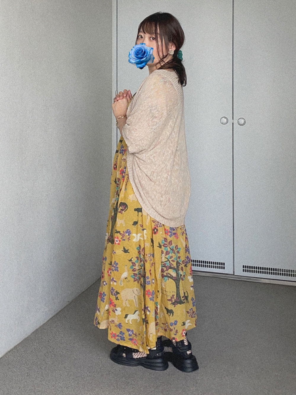 ベージュ系のカーディガン/ボレロ、イエロー系のワンピース、ブラック系のサンダルを着用したレディースの秋コーディネートの2枚目の写真