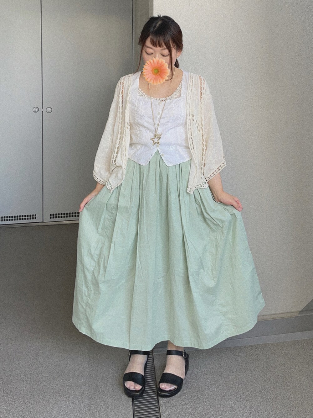 ホワイト系のカーディガン/ボレロ、ホワイト系のベスト、グリーン系のスカートを着用したレディースの夏コーディネートの3枚目の写真