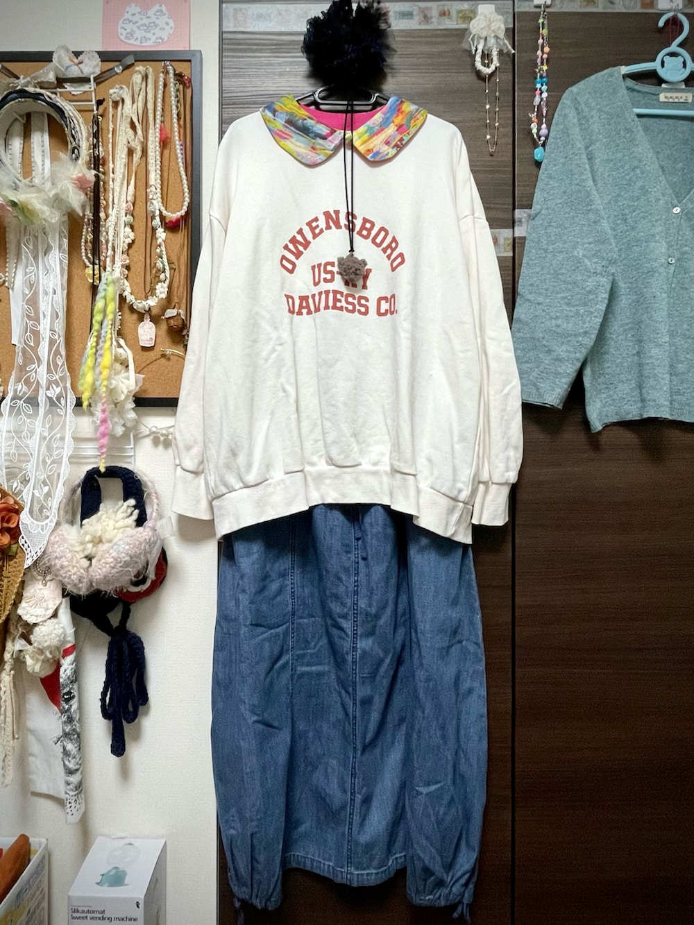 ホワイト系のスウェット、ブルー系のデニムスカート、グレー系のブーティを着用したレディースの冬コーディネートの5枚目の写真