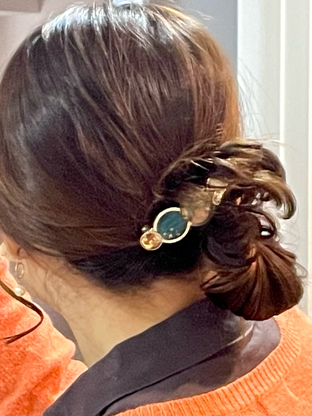 ブラック系のシャツ/ブラウス、オレンジ系のカーディガン/ボレロ、ブラウン系のチノパンツを着用したレディースの冬コーディネートの4枚目の写真