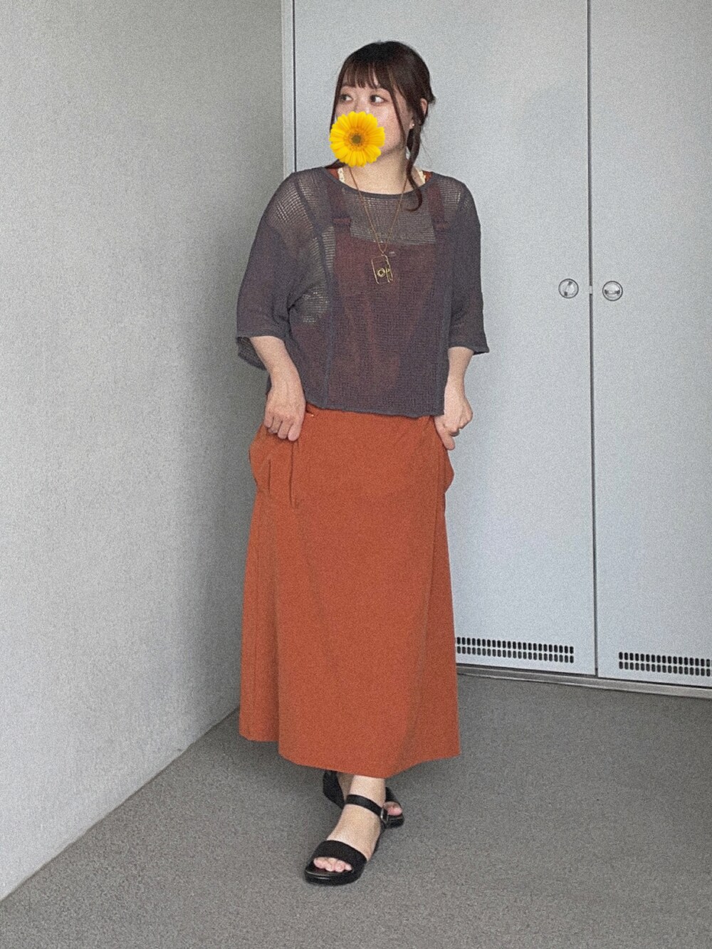 グレー系のTシャツ/カットソー、オレンジ系のジャンパースカート、ブラック系のサンダルを着用したレディースの夏コーディネートの2枚目の写真