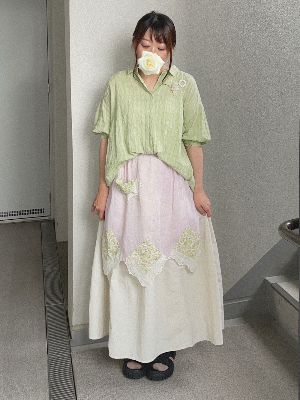 グリーン系のシャツ/ブラウス、ホワイト系のスカート、ブラック系のサンダルを着用したレディースの秋コーディネートの2枚目の写真