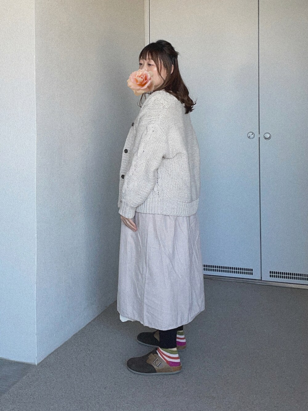 グレー系のワンピース、ホワイト系のニット/セーター、ホワイト系のスカートを着用したレディースの春コーディネートの2枚目の写真