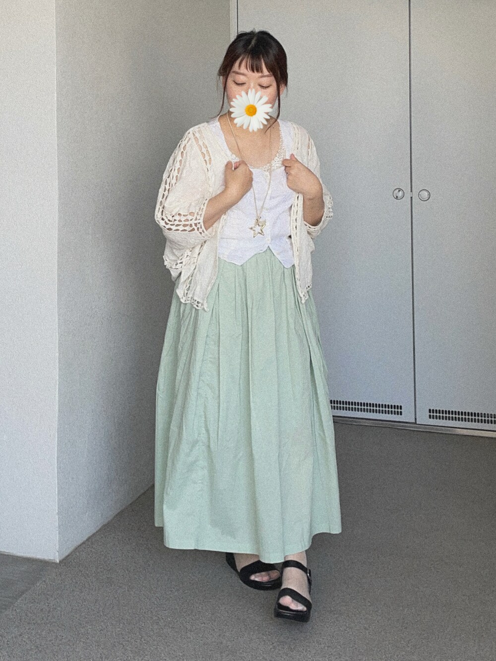 ホワイト系のカーディガン/ボレロ、ホワイト系のベスト、グリーン系のスカートを着用したレディースの夏コーディネートの2枚目の写真