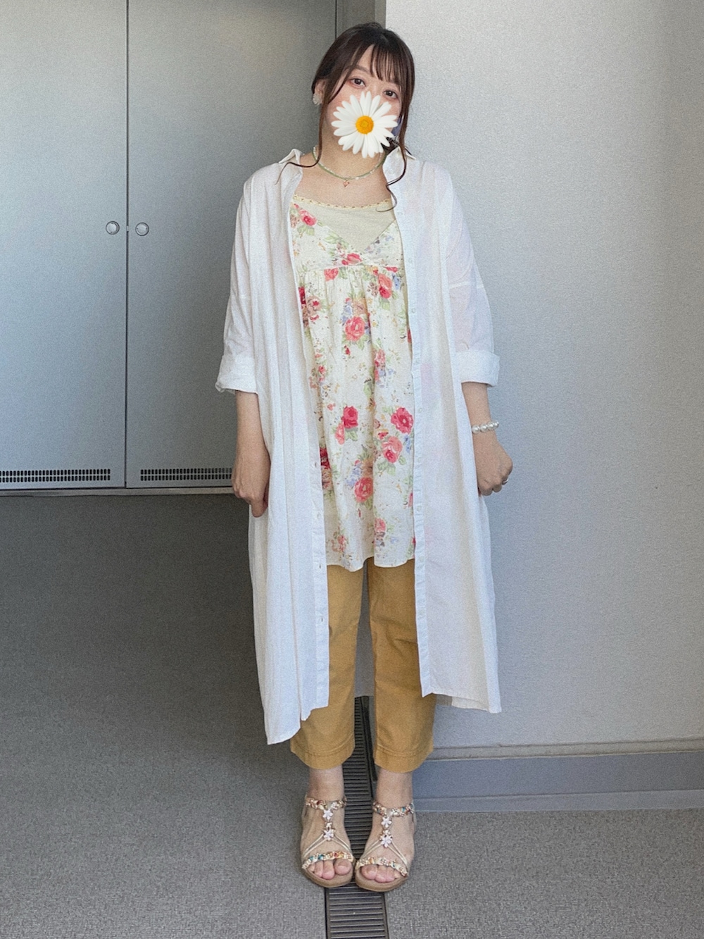 イエロー系のチノパンツ、ホワイト系のシャツワンピース、ベージュ系のチュニックを着用したレディースの夏コーディネートの3枚目の写真