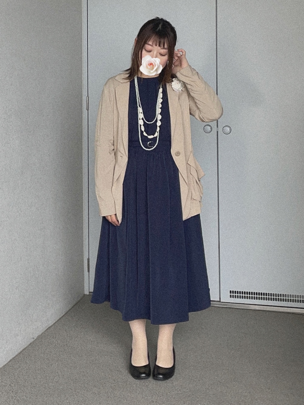 ブルー系のワンピース、ベージュ系のジャケット/アウター、ブラック系のパンプスを着用したレディースの春コーディネートの2枚目の写真