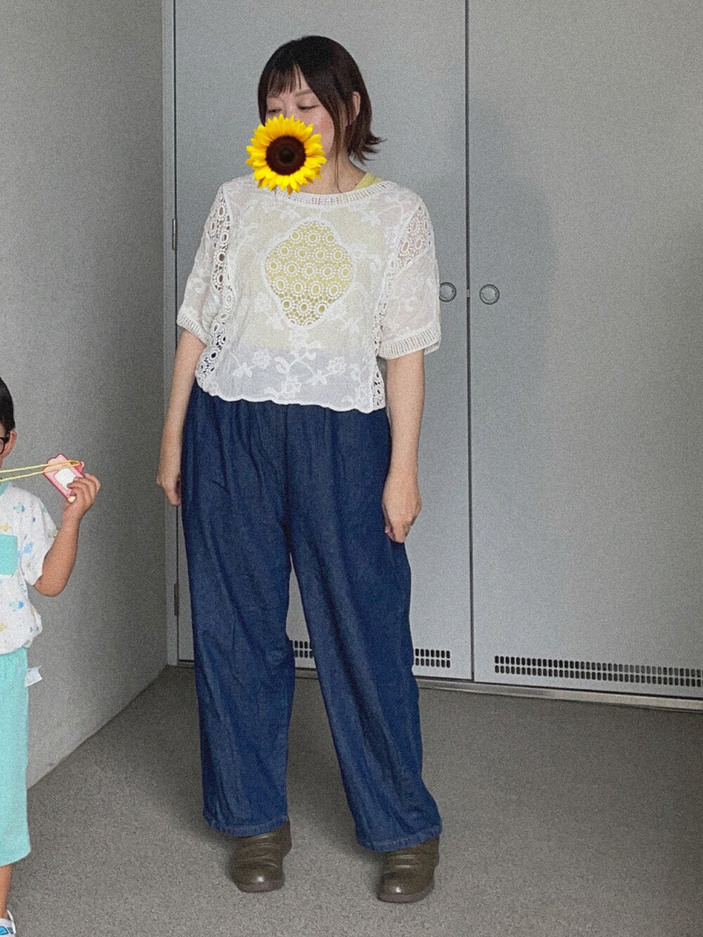 ホワイト系のTシャツ/カットソー、ブルー系のデニムパンツ、グリーン系のブーティを着用したレディースの秋コーディネートの2枚目の写真