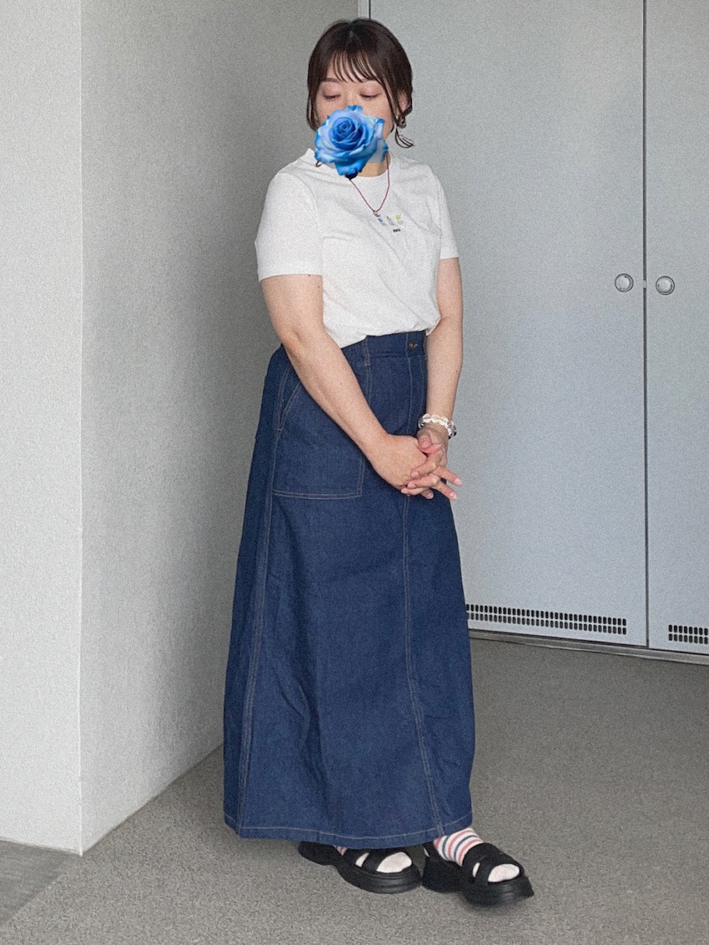 ホワイト系のTシャツ/カットソー、ブルー系のデニムスカート、ブラック系のサンダルを着用したレディースの秋コーディネートの2枚目の写真