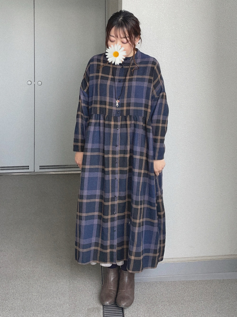 ピンク系のスカート、ブルー系のシャツワンピース、グレー系のブーティを着用したレディースの冬コーディネートの3枚目の写真