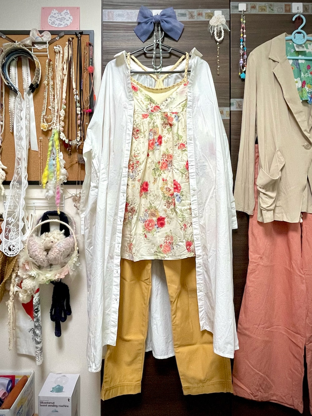 イエロー系のチノパンツ、ホワイト系のシャツワンピース、ベージュ系のチュニックを着用したレディースの夏コーディネートの5枚目の写真