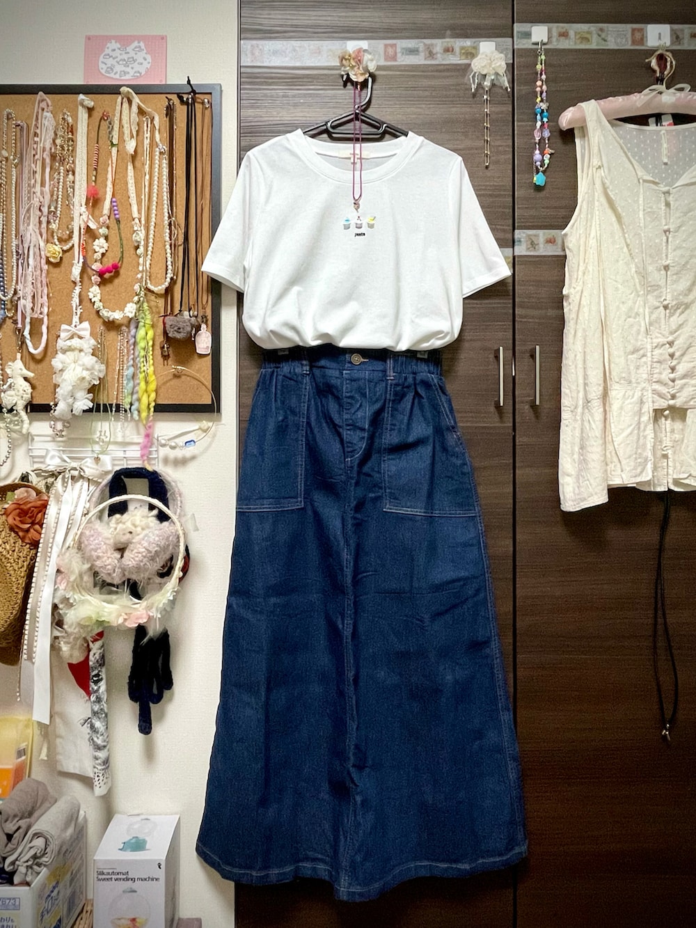 ホワイト系のTシャツ/カットソー、ブルー系のデニムスカート、ブラック系のサンダルを着用したレディースの秋コーディネートの5枚目の写真