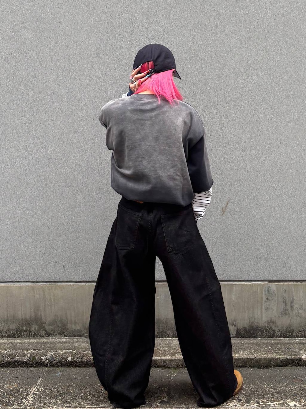 ホワイト系のTシャツ/カットソー、ブラック系のデニムパンツ、ブルー系のキャップを着用したレディースの春コーディネートの4枚目の写真