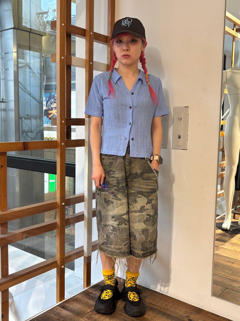 グリーン系のデニムパンツ、ブルー系のポロシャツ、ブラック系のタンクトップを着用したレディースの夏コーディネートの8枚目の写真