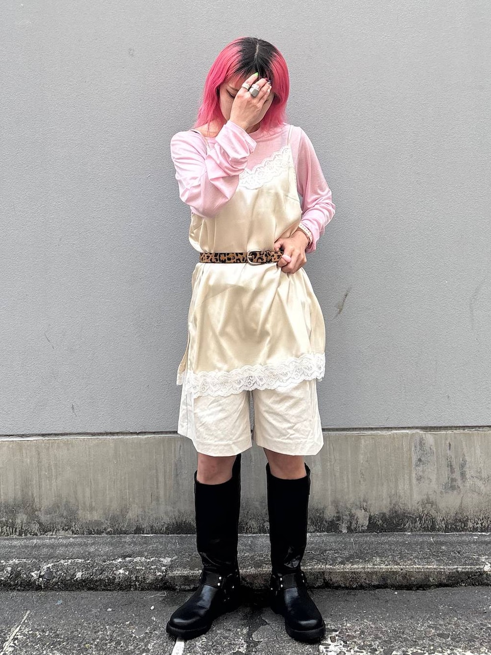 ブラック系のブーツ、ホワイト系のスラックス、ホワイト系のキャミソールを着用したレディースの春コーディネートの2枚目の写真