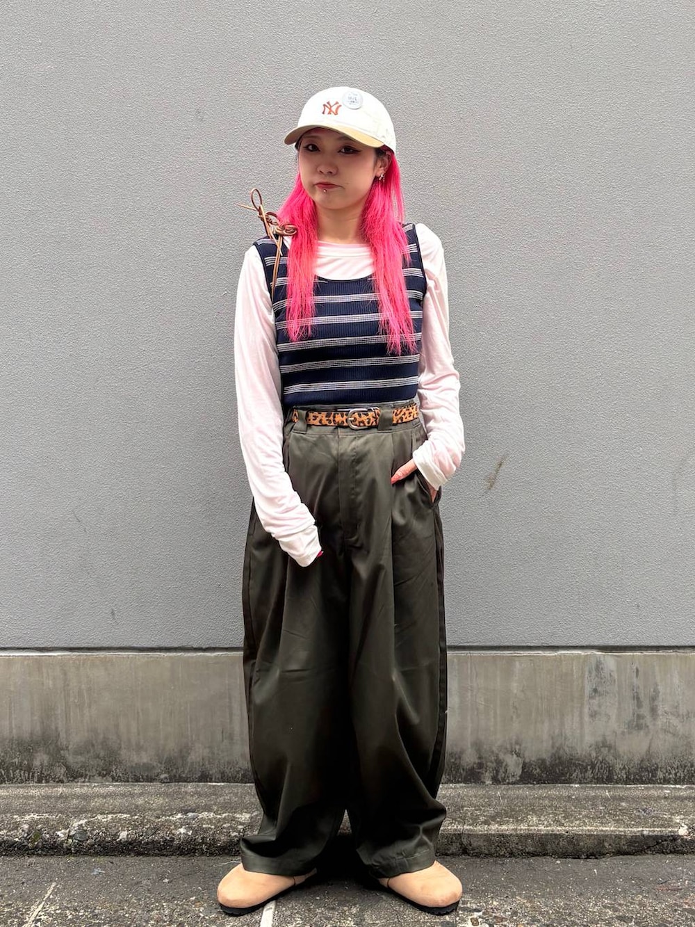 ベージュ系のショルダーバッグ、グリーン系のチノパンツ、ベージュ系のモカシン/デッキシューズを着用したレディースの春コーディネートの7枚目の写真